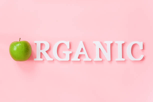 istock Natural green apple and text Organic from volume white letters on pink background. Creative concept Organic natural fruits food Top view Flat lay Copy space 1192844139