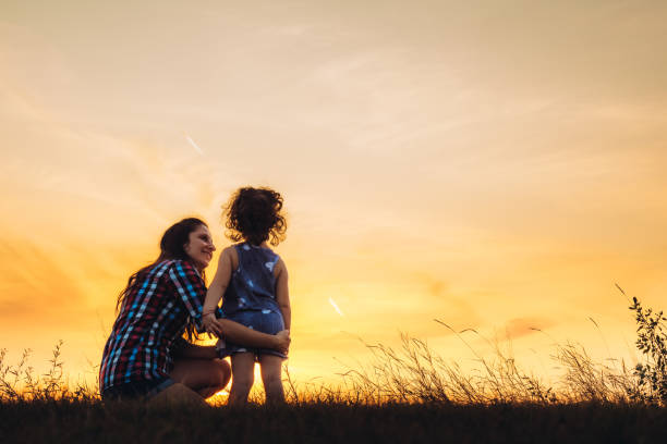 istock Mother and daughter embracing at sunset 1192844598