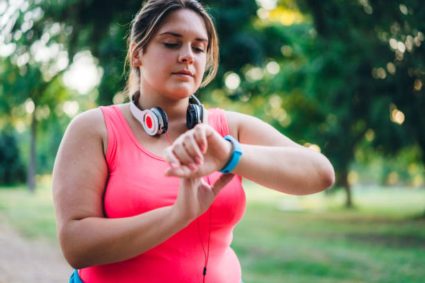 istock Female overweight runner checking smart watch 1192844671