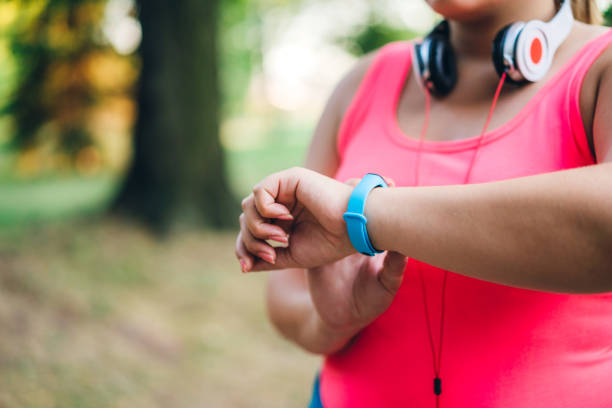 istock Female overweight runner checking smart watch 1192844684