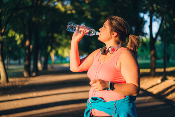 istock Oversized woman drinking water after running 1192844719