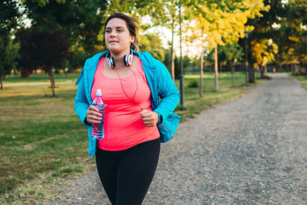 istock Young overweight woman running 1192844861