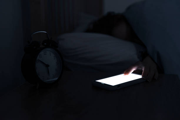 istock Woman reaching and switching off disturbing calls from work on smartphone while sleeping at midnight 1192845897