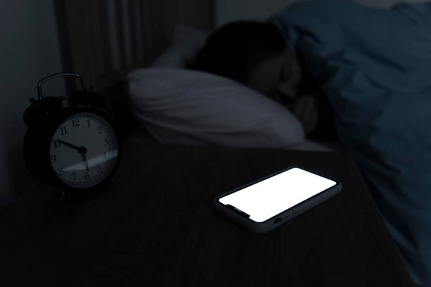istock Woman reaching and switching off disturbing calls from work on smartphone while sleeping at midnight 1192845953