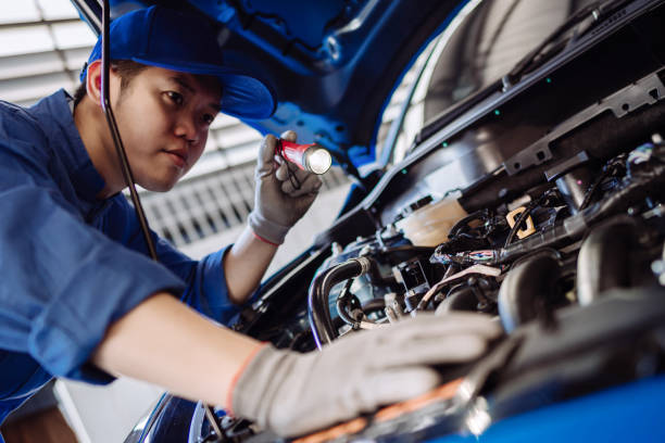 homme de mécanicien examinant et entretien par l'intermédiaire du système d'assurance fixent le moteur un capot de véhicule, inspection de sécurité avant que le client conduise sur un long voyage, centre de service de garage de réparation de transpo - automotive repair center photos et images de collection