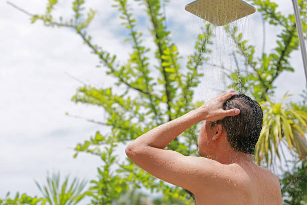 istock Low Angle View Of Man Taking Shower Outdoors 1192848041
