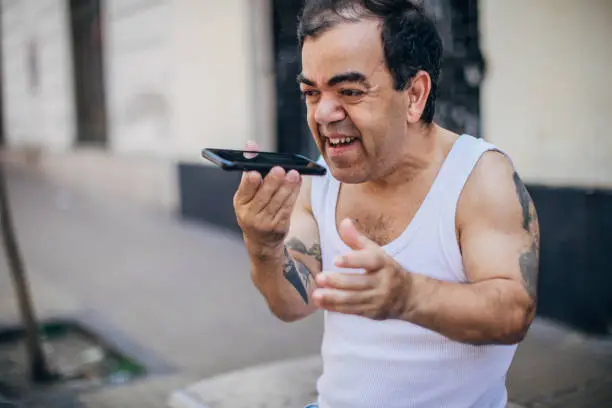 Photo of Little man using phone on the street