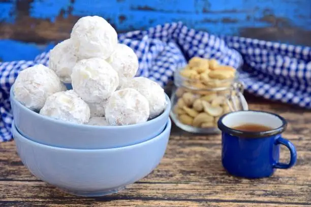 Traditional Christmas cashew snowballs cookies biscuits covered icing sugar powder. Served with tea