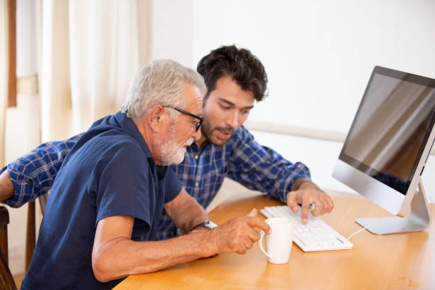 istock Man Showing Computer Key To Father While Sitting On Table At Home 1192851485