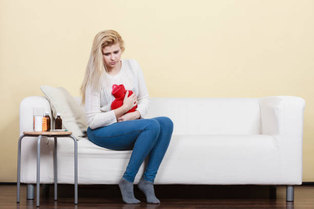istock Woman feeling stomach cramps sitting on cofa 1192851811