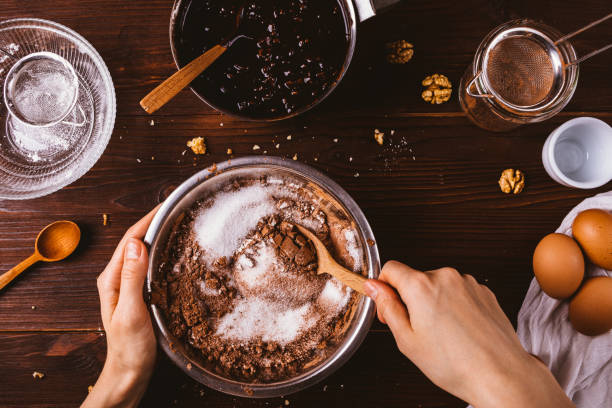 le mani femminili in alto mescolano cacao in polvere - cake foto e immagini stock