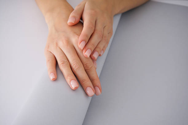 istock Women's hands with a nice manicure on white-gray background. 1192856138