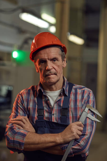 mature foreman working in the factory - manual worker portrait helmet technology imagens e fotografias de stock