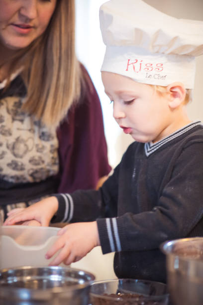 istock Mother with her son making preparation for baking cookies 1192858883