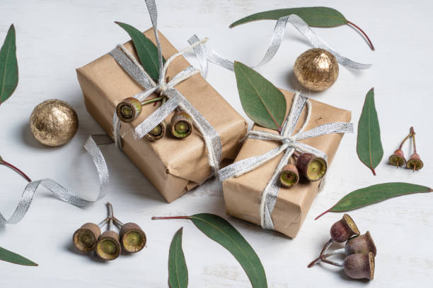 istock Gifts, gum nuts and eucalyptus leaves on a rustic white background. 1192860470