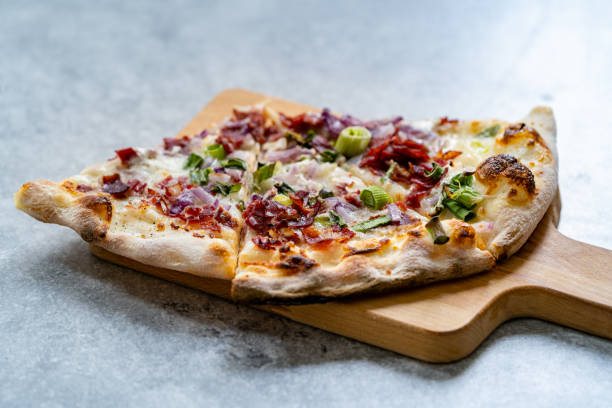 flammkuchen pizza slices / traditional tarte flambee with creme fraiche, cream cheese, bacon and red onions on wooden board. - creme fraiche imagens e fotografias de stock