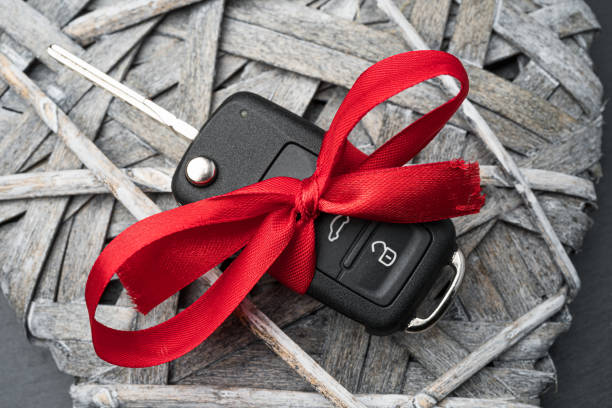 istock Car key with red bow on a wooden heart. 1192863840