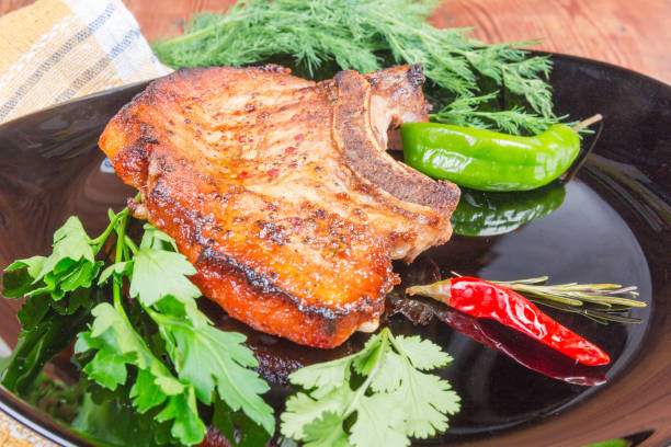 istock Grilled pork loin chop bone-in on dish close-up 1192865106