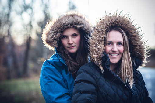 Lesbian, Love, Equality - Image of a Young Lesbian couple wearing winter fur coat smiling at the camera for a portrait