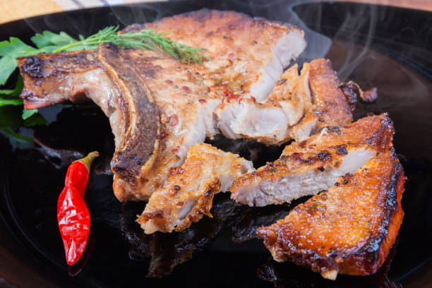 istock Grilled pork loin chop bone-in on dish, partly cut 1192866154