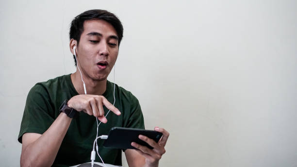 millennials asiatici emotivi che giocano a videogiochi a letto - overemotional foto e immagini stock