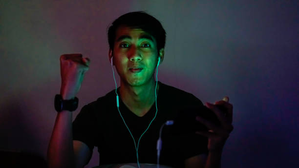 istock Asian Millennials Playing Mobile Games In Dark Room 1192867726