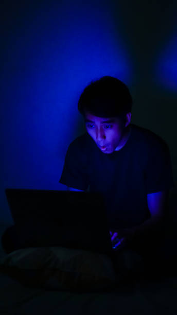 istock Asian Millennials Playing Game In The Dark Room Blue Background 1192867826