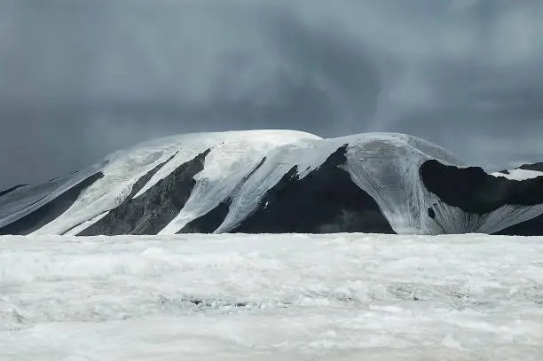 gray stormclouds over the mountains, flat top, glacier, snow line, alpine tableland, Mongolia