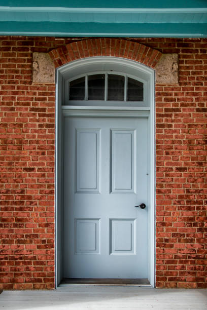 Blue door on a brick building a picture of a Blue door on a brick building blue front door stock pictures, royalty-free photos & images