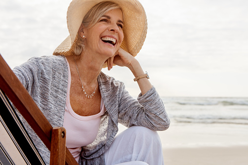 Cropped shot of an attractive middle aged woman sitting on a lounger at the beach