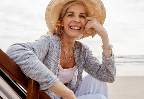 Cropped portrait of an attractive middle aged woman sitting on a lounger at the beach