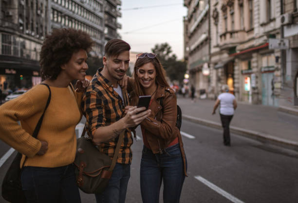 istock Group of friends using smart phone outdoors 1192872091