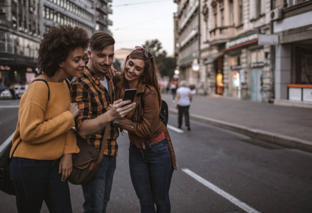 istock Group of friends using smart phone outdoors 1192872433