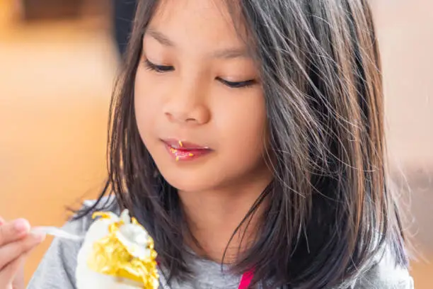 Photo of Japanese girl tourist is eating gold leaf ice cream in an ice cream shop in Kanazawa.