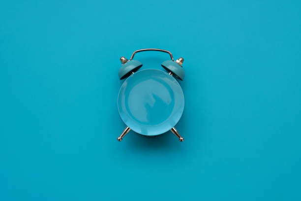 istock Time to eat. Empty plate as clock on blue background. Mock-up. Top view. Flat lay. Weight loss and diet concept 1192878256