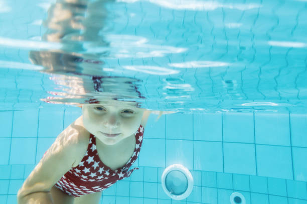 istock Funny child dive underwater in swimming pool 1192883910