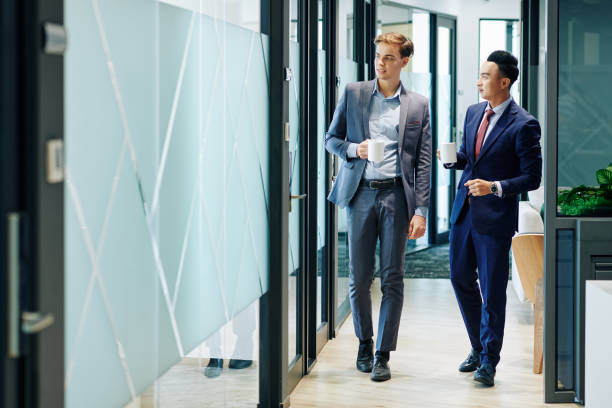 istock Business people walking along office corridor 1192887425