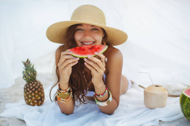 istock Woman on the Beach Eating Watermelon 1192887427