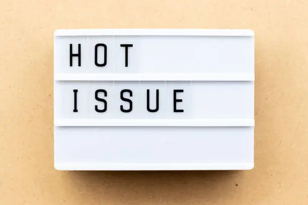 Photo of Light box with word hot issue on wood background
