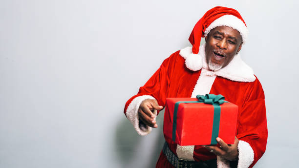 istock Santa Claus holding christmas gift on grey background 1192890185
