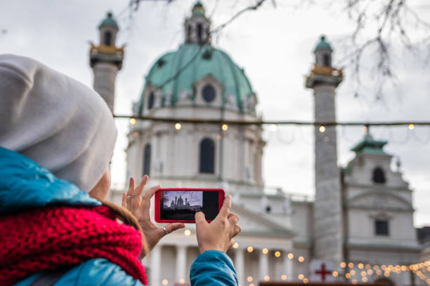 ricordi di vacanza. donna che fotografa karlsplatz, vienna sul suo smartphone. - karlsplatz foto e immagini stock