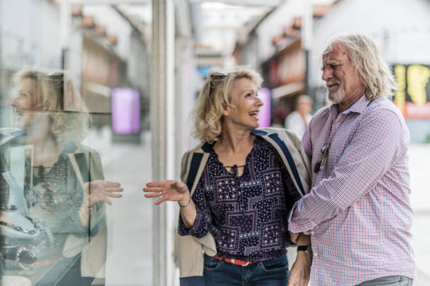 senior woman persuading husband to buy her jewelry - persuasion pleading men women imagens e fotografias de stock