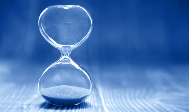 istock Hourglass on a modern trendy blue background, time and glass 1192893425