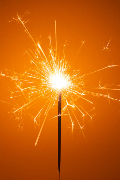 istock Party sparkler little fireworks on orange background. 1192893689