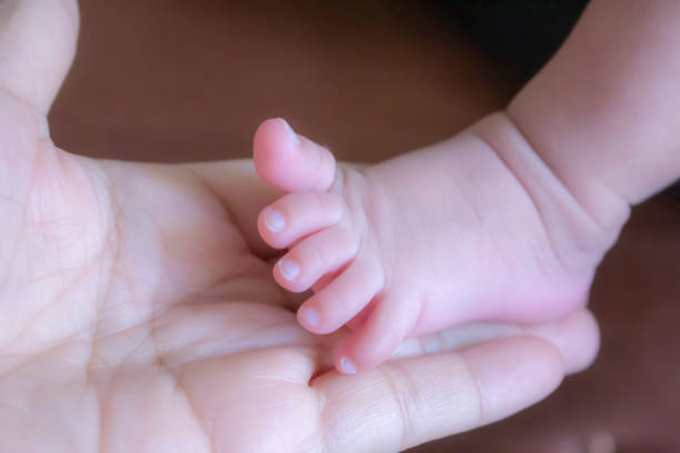 Baby's leg in Mom's hand