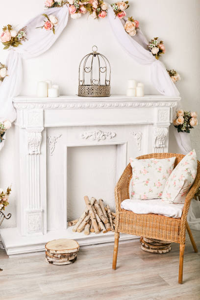 istock Wicker chair by a white decorative fireplace with firewood in a light interior 1192893946