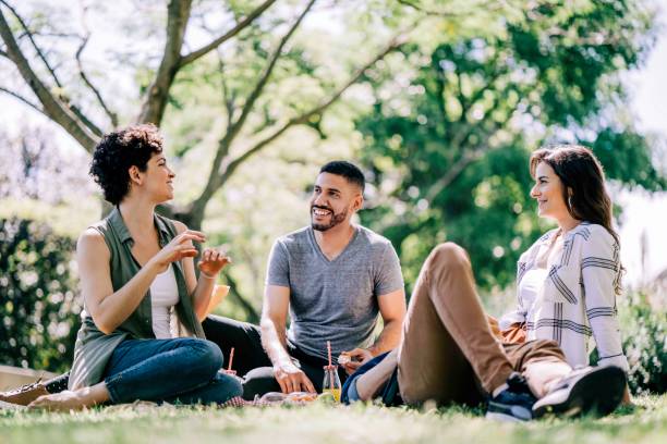 istock Happy friends discussing while relaxing in park 1192895625