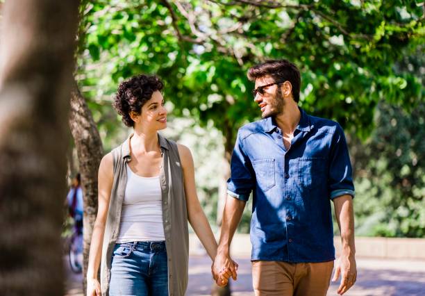 istock Couple walking in park during sunny day 1192895736
