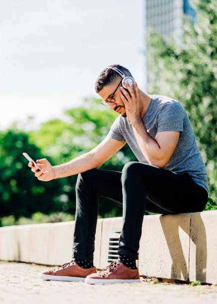 istock Male using mobile phone in park on sunny day 1192895839