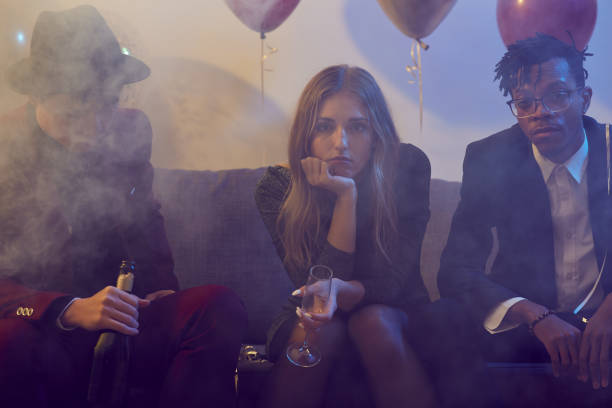 Depressed Young Woman in Nightclub Portrait of drunk young woman holding champagne glass while siting on sofa during party in smoky nightclub boring drink stock pictures, royalty-free photos & images
